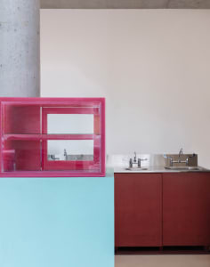 Modern bathroom with a pink cabinet, sink, and mirror, featuring clean lines and minimalistic elements
