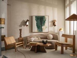 A modern living room with a couch, coffee table, chairs, paintings, and well-lit atmosphere