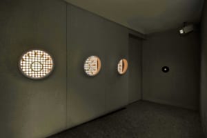 Empty industrial office hallway with concrete walls, three round lights, and a functional atmosphere