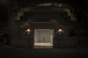 Spacious entrance with brick walls, modern doors, and an inviting archway leading to a warm and rustic interior