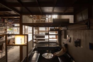 Cozy living and dining space with a mix of chairs, a dining table, coffee table, couch, and bench, creating a warm and inviting atmosphere for socializing and relaxation