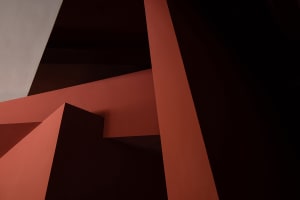 A modern staircase in a red room with a warm and inviting atmosphere, possibly featuring concrete or wood materials