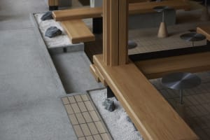 Cozy living space with wooden floors and walls, featuring benches with rocks and a warm atmosphere