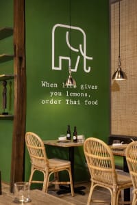 Cozy dining area with a table, chairs, green walls, and various items on the table