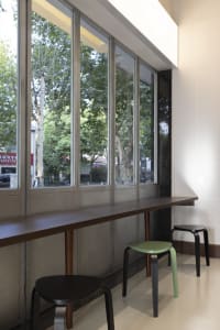 A rendered room with a large window, two chairs, and a bench, providing a comfortable and inviting atmosphere