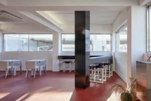 A modern restaurant interior with a large dining area featuring multiple tables and chairs, creating a comfortable and inviting atmosphere
