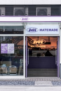 A modern office space with a purple facade, featuring a large window with a city skyline view, comfortable seating, and stylish design