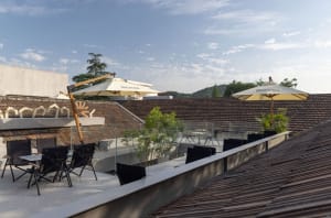 A rooftop patio with tables, chairs, and umbrellas, creating a modern and inviting outdoor space