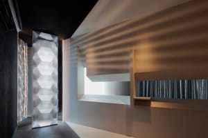 Bathroom with a sink and mirror, featuring concrete walls and well-lit interior