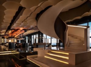 A spiral staircase made of concrete winds its way through multiple levels of a building, creating a sense of depth and complexity
