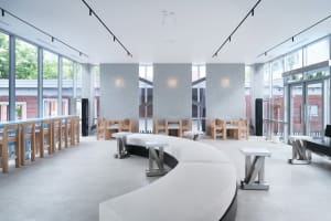 Open restaurant interior with modern design, multiple tables, benches, and warm ambient lighting