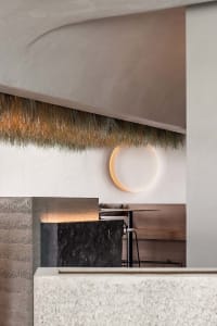 Dining space with a stone countertop, a thatch ceiling, and two dining tables, a chair, and a vase