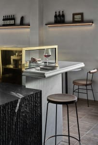 Elegant wine bar with a marble countertop, two chairs, and a wine glass, set in a sophisticated atmosphere with warm lighting