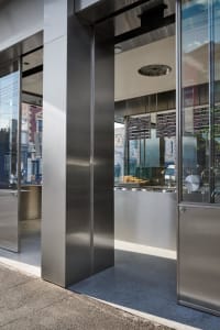 Industrial kitchen with a steel column, modern countertops, and well-organized storage and preparation space