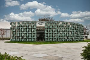 A modern building with a circular design and a glass facade, surrounded by a bright and inviting atmosphere