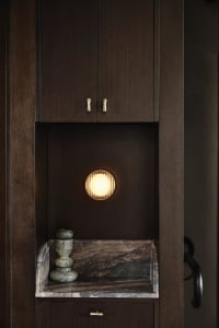 A wooden kitchen cabinet with a light on inside, creating a warm atmosphere