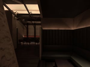 Dark restaurant interior with a large couch and comfortable seating arrangements, creating a mysterious atmosphere for socializing and relaxation