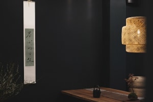 A calm and inviting interior space with a wooden table, vases, and a bowl, featuring warm wooden elements