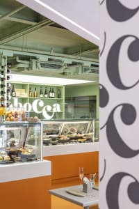 A restaurant interior with glass cases displaying a variety of food items and bottles, creating an inviting and well-organized atmosphere