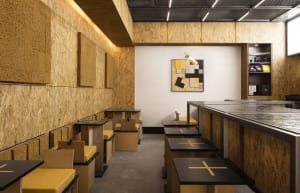 Warm and inviting cafe with wooden walls, tables, and chairs, designed for a large number of guests