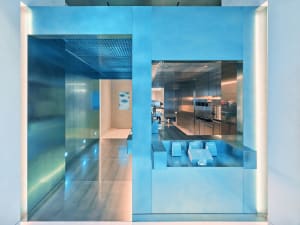 Modern kitchen with a large countertop island, stainless steel appliances, and soft diffused lighting
