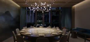 A luxurious dining area with a round glass table, wine glasses, and multiple cups, set in a refined atmosphere