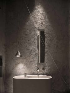 Bathroom with a white marble sink, large mirror, and two faucets, giving a modern and luxurious feel