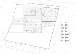 Black and white floor plan of a hotel with various rooms, including a lobby and dining area, featuring concrete and wood materials