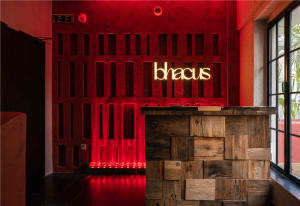 Professional office space with a modern reception desk made of wood, illuminated by side lights, and two chairs in front