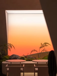 Three round tables and chairs in a well-lit dining area with natural light from large windows