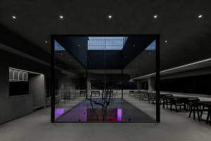A modern indoor pool area with chairs around the pool, featuring a purple glow and well-lit surroundings