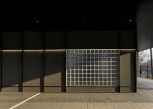Modern building with a large glass window featuring a checkered pattern, set against a clean and minimalistic backdrop