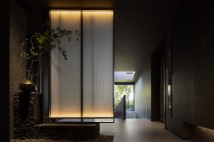 A bright and inviting hallway with concrete walls, large sliding glass doors, and natural light