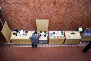 A casual indoor space with a brick wall, a wooden countertop, and various objects and people arranged in a relaxed atmosphere