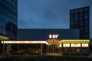 Sleek modern building with a glass exterior, a large sign reading 569, and a seating area with several chairs