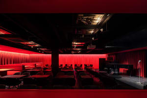 Cozy modern restaurant interior with red walls, black tables, and various chairs, creating a welcoming atmosphere