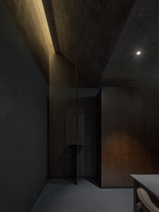 Cozy modern dining room with a wooden table, brown cabinet, and two chairs in a dimly lit space
