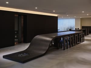 A modern dining space with a long wooden table and chairs, creating a warm and inviting atmosphere
