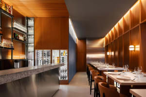 Modern restaurant interior with a large bar area, dining tables, and comfortable seating for guests