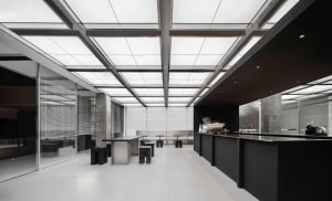 Modern restaurant interior with a large dining area, multiple tables, chairs, and couches, featuring a sleek and functional design
