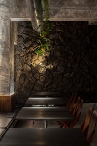 A restaurant dining area with multiple wooden tables and chairs arranged in rows, creating a comfortable seating arrangement for guests