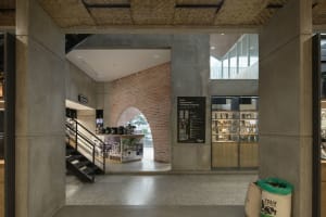 Open modern space with a concrete floor, a staircase, and large windows providing natural light
