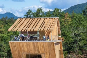 A wooden deck area with people enjoying the mountain view and each other's company