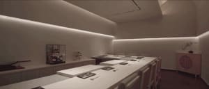 Empty restaurant dining area with white walls, tables, and chairs, in need of decoration
