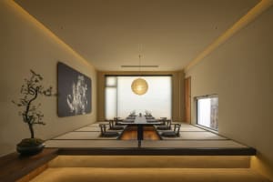 A clean and organized dining area with a long wooden table and chairs, wine glasses, and a focus on functionality and elegance