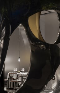 Dining area with a modern table and chairs, surrounded by black and white walls and a bowl and wine glasses on the table