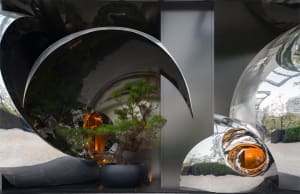 A modern living space with a glass sculpture featuring a small tree, clean lines, and reflective surfaces