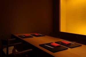A warm and inviting dining area with a wooden table, red napkins, and utensils, perfect for a meal with friends or family