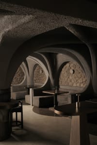 Cozy restaurant interior with stone walls, wooden furniture, and warm lighting