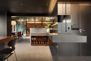 Modern kitchen with a countertop island, sink, and two chairs, featuring a well-organized and modern atmosphere
